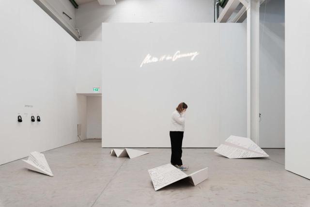 an exhibition and a person looking at the letter on the floor